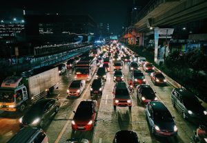 A bustling urban highway filled with cars and buses at night, showcasing city life and transportation.